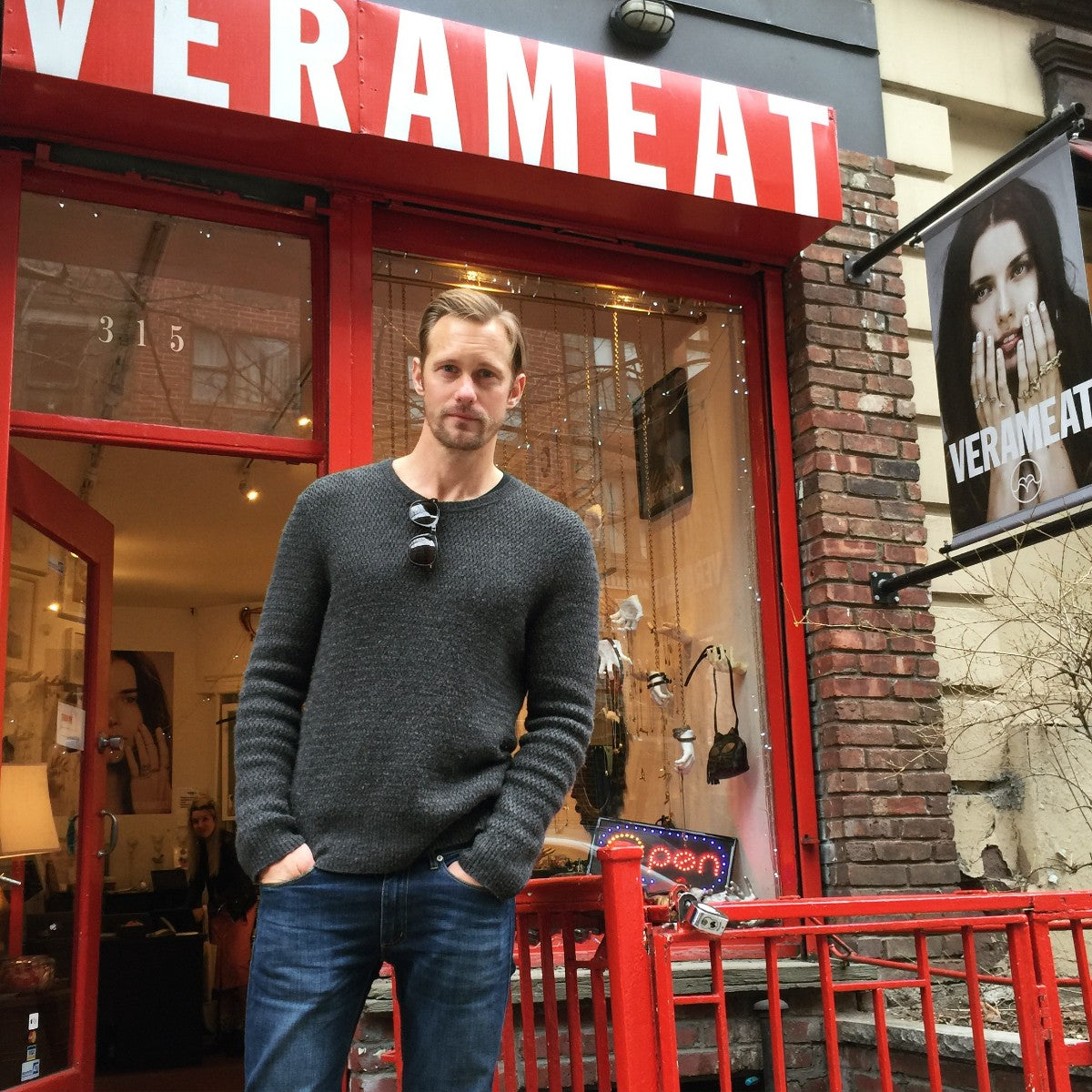 Alex Skarsgard posing outside VeraMeat's shop with their exclusive Handsy Sunglasses